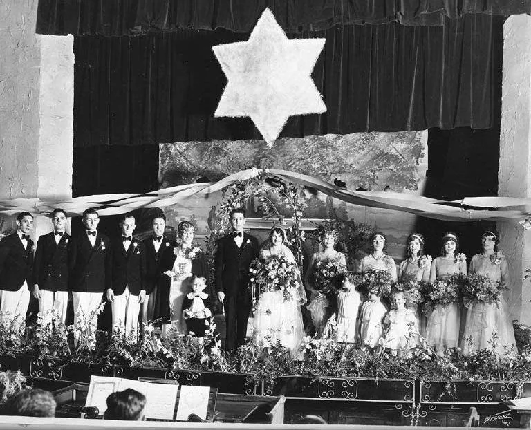 Bryant and Lola Lee Mitchell's wedding. Aimee Semple McPherson is standing next to Bryant. Bryant's brother Hubert Mitchell is best man. 