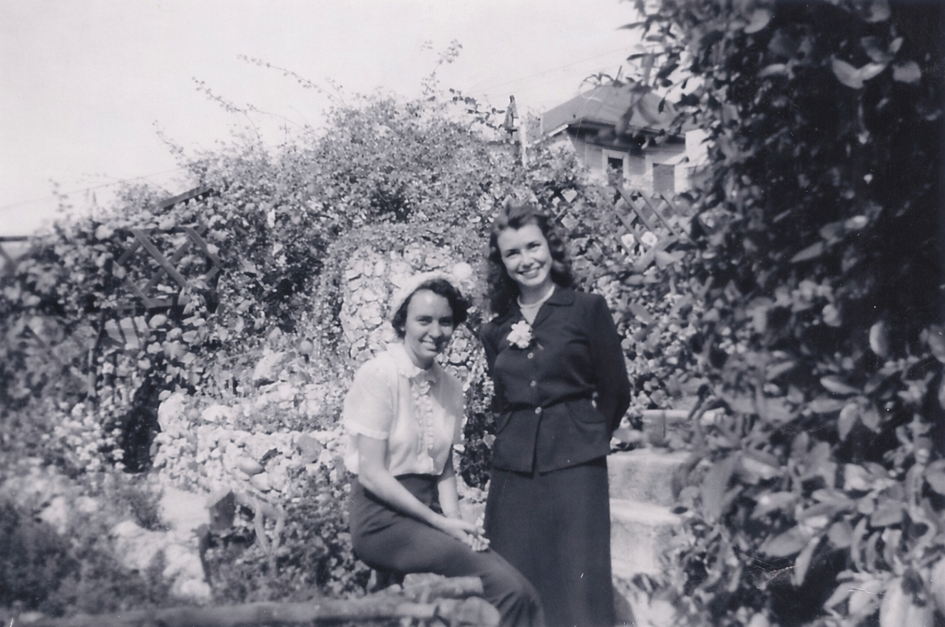 Granddaughter of A.E. Mitchell, Avonna Lee Mitchell, and friend in the Go-Ye Fellowship prayer garden with the Victory Vase in the background, 1942