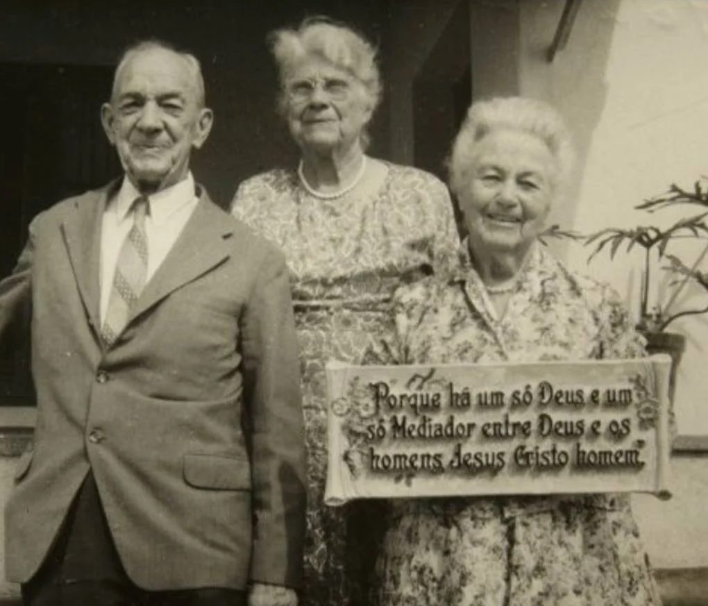 Andrew, Jennie and Jennie's sister Nellie in Brazil with a plaque in the Portuguese language.