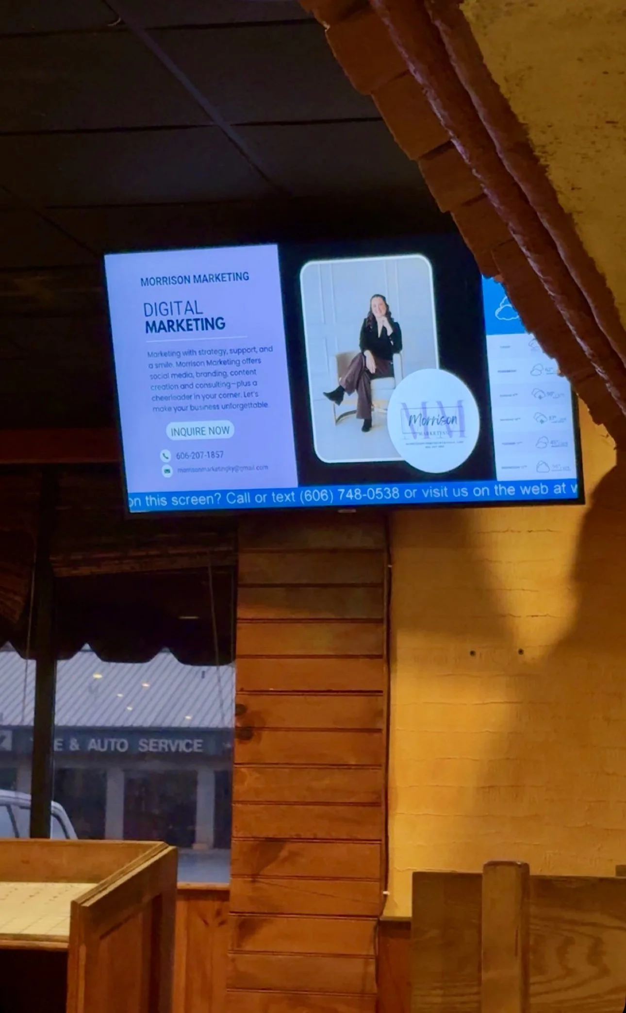 Digital marketing advertisement on a digital screen in a restaurant with wooden interiors.