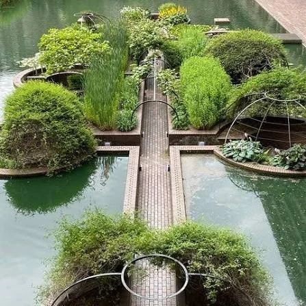 A brick bridge crosses the ponds inside the Barbican Conservatory.