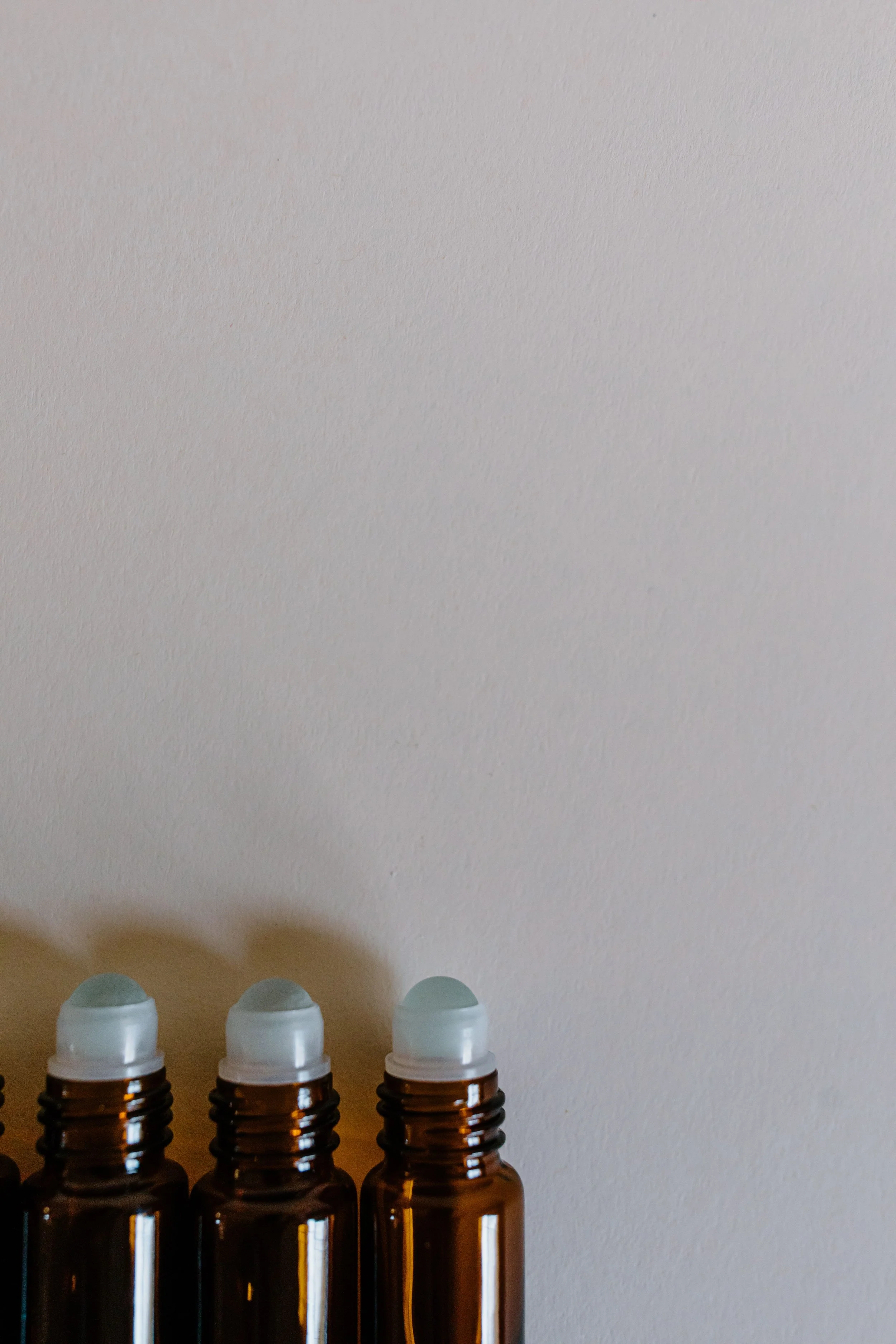 Three amber essential oil roller bottles for an online aromatherapy blending workshop