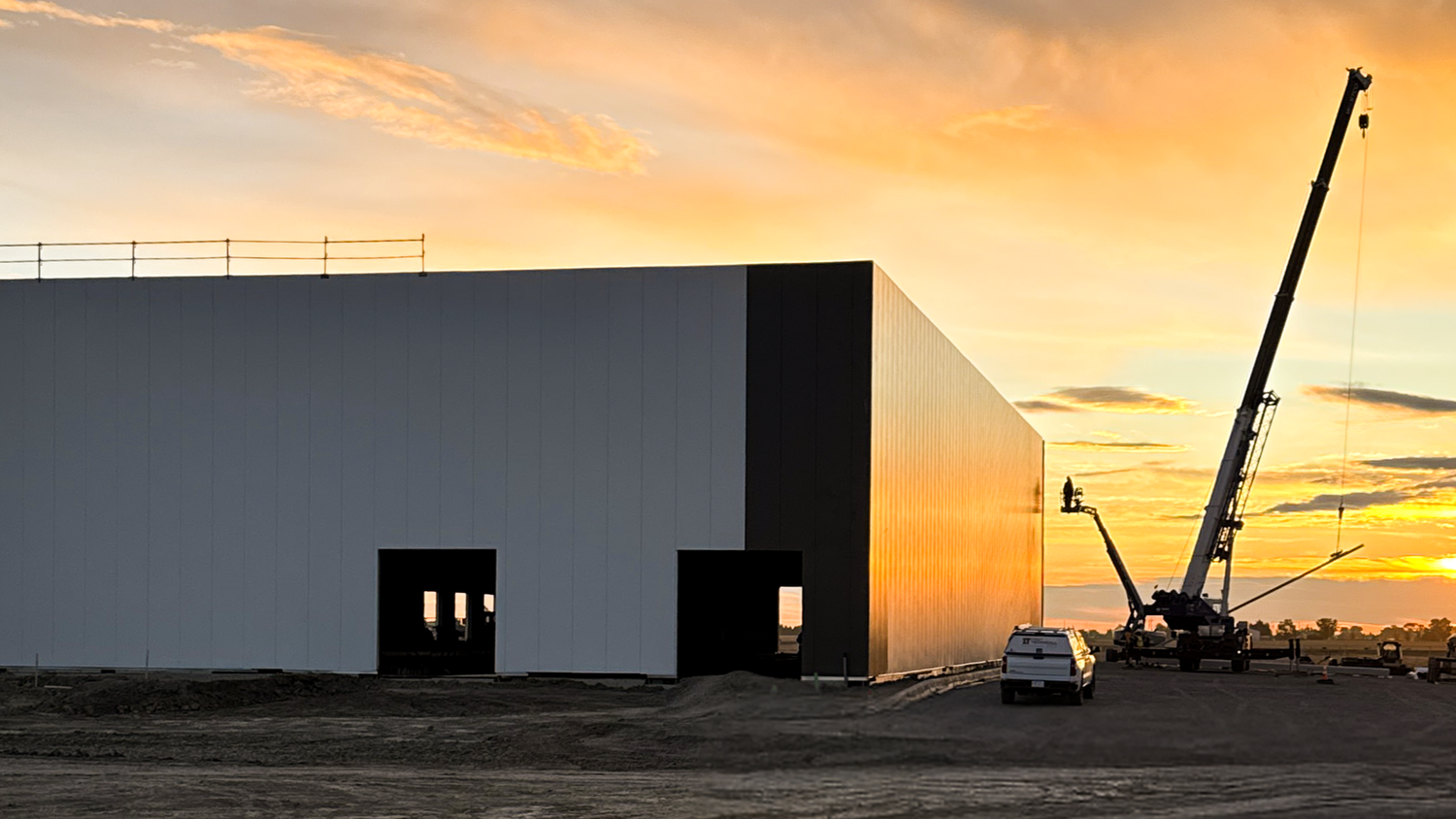 Building envelope going on at sunrise, with a crane still in the yard.