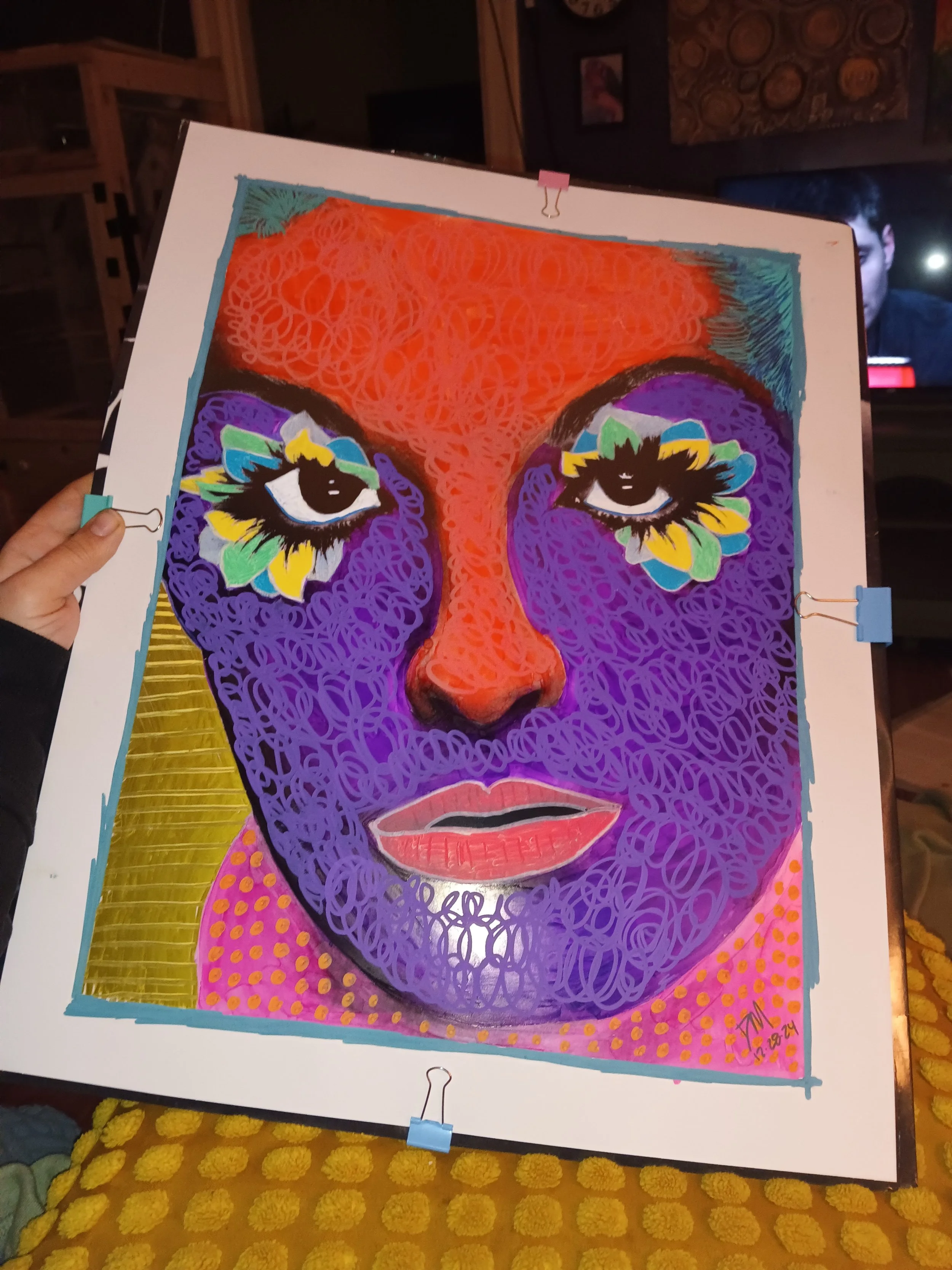 A colorful abstract portrait of a woman's face with stylized eyes and lips, created with scribble-like patterns and vibrant colors including purple, orange, yellow, green, and pink.