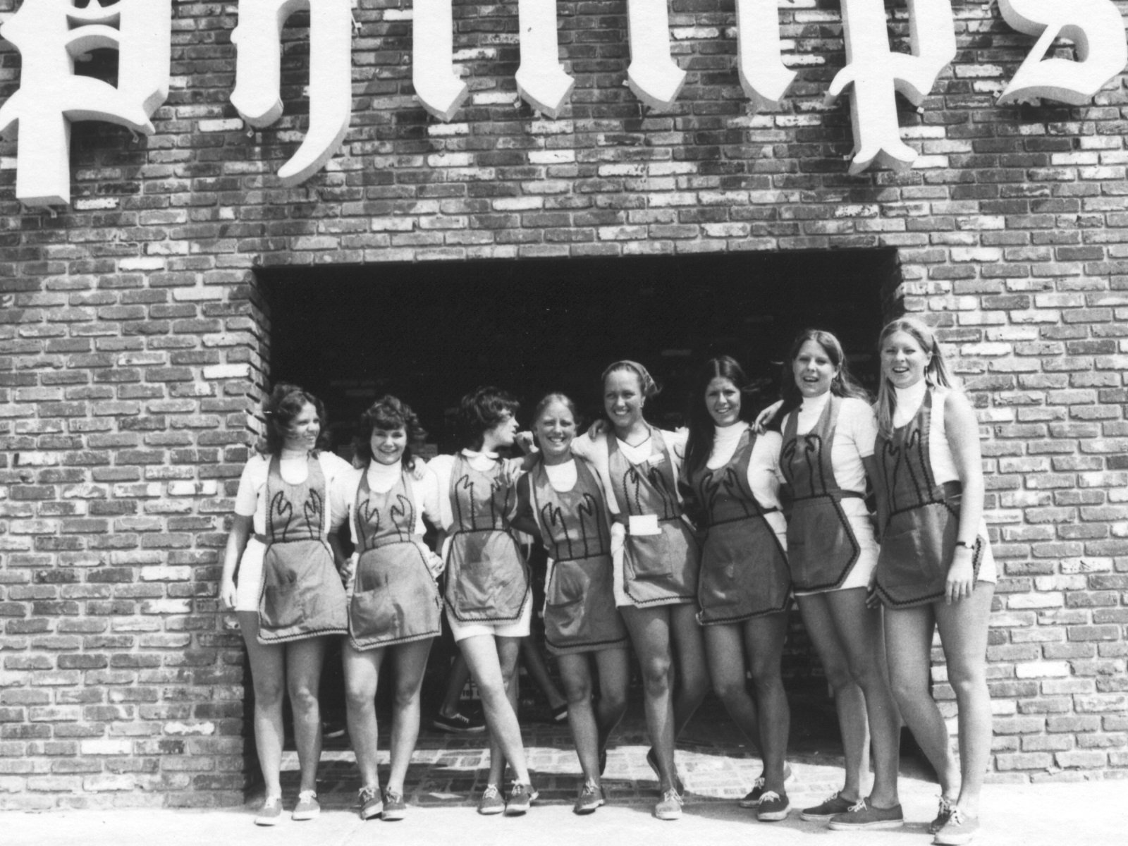  Vintage black and white photograph of a line of waitresses standing outside the Phillips Crab House, wearing crab aprons.  