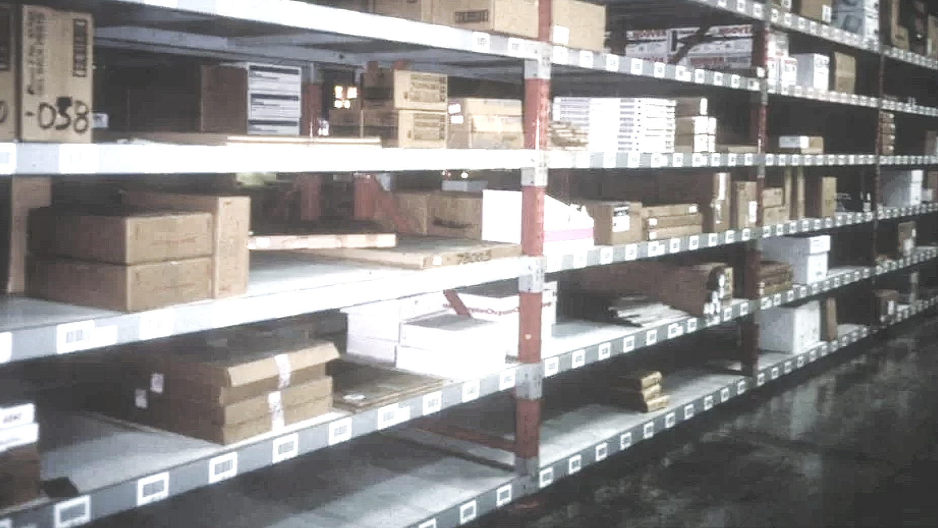 Empty warehouse shelves stocked with cardboard boxes and packages.