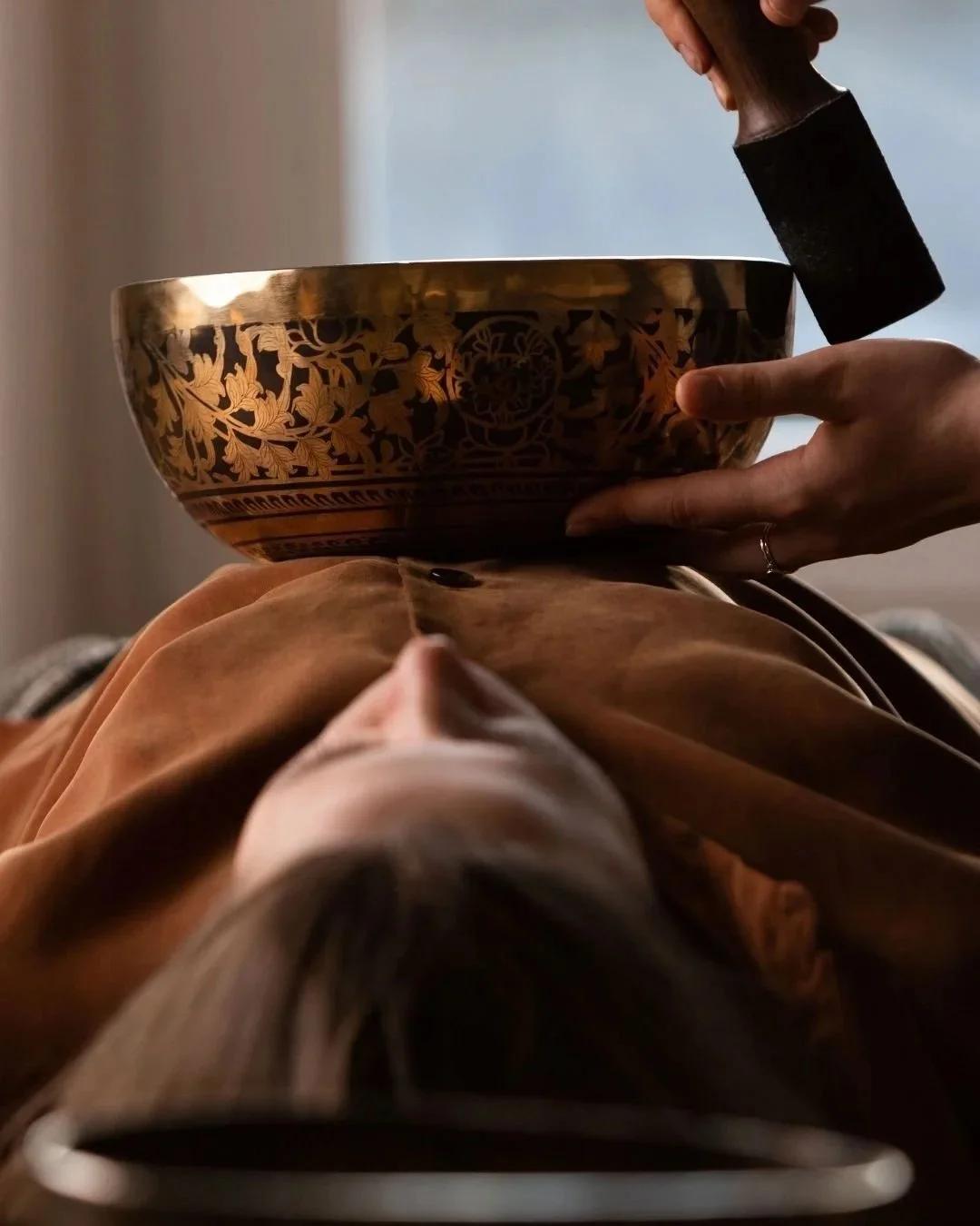 sound bowl being used on top of a person meditating