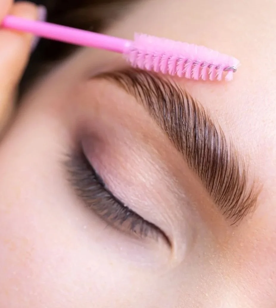 girl brushing her laminated brows