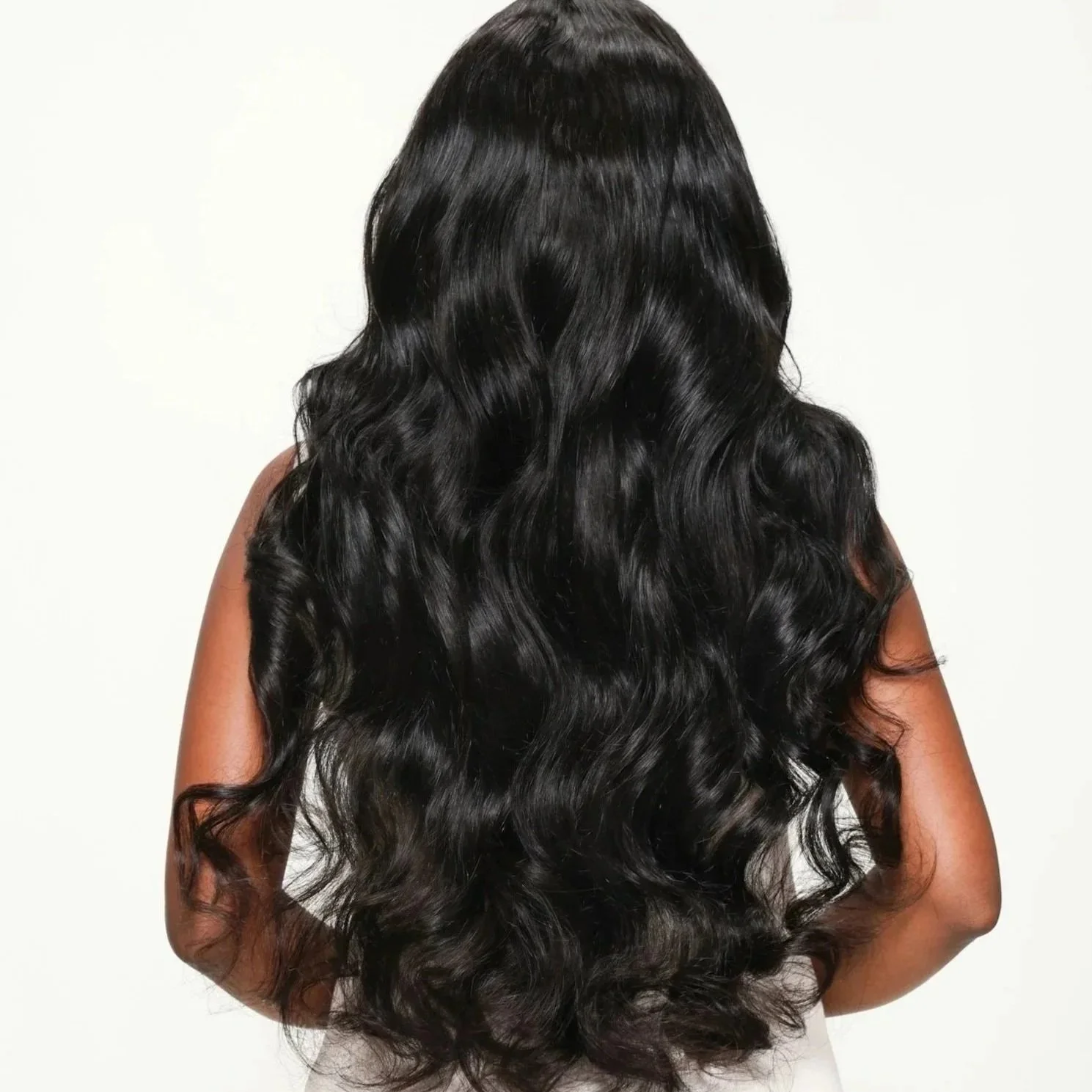 Long, healthy black hair styled in soft waves at Adrianna’s Color Bar in Richardson, TX.