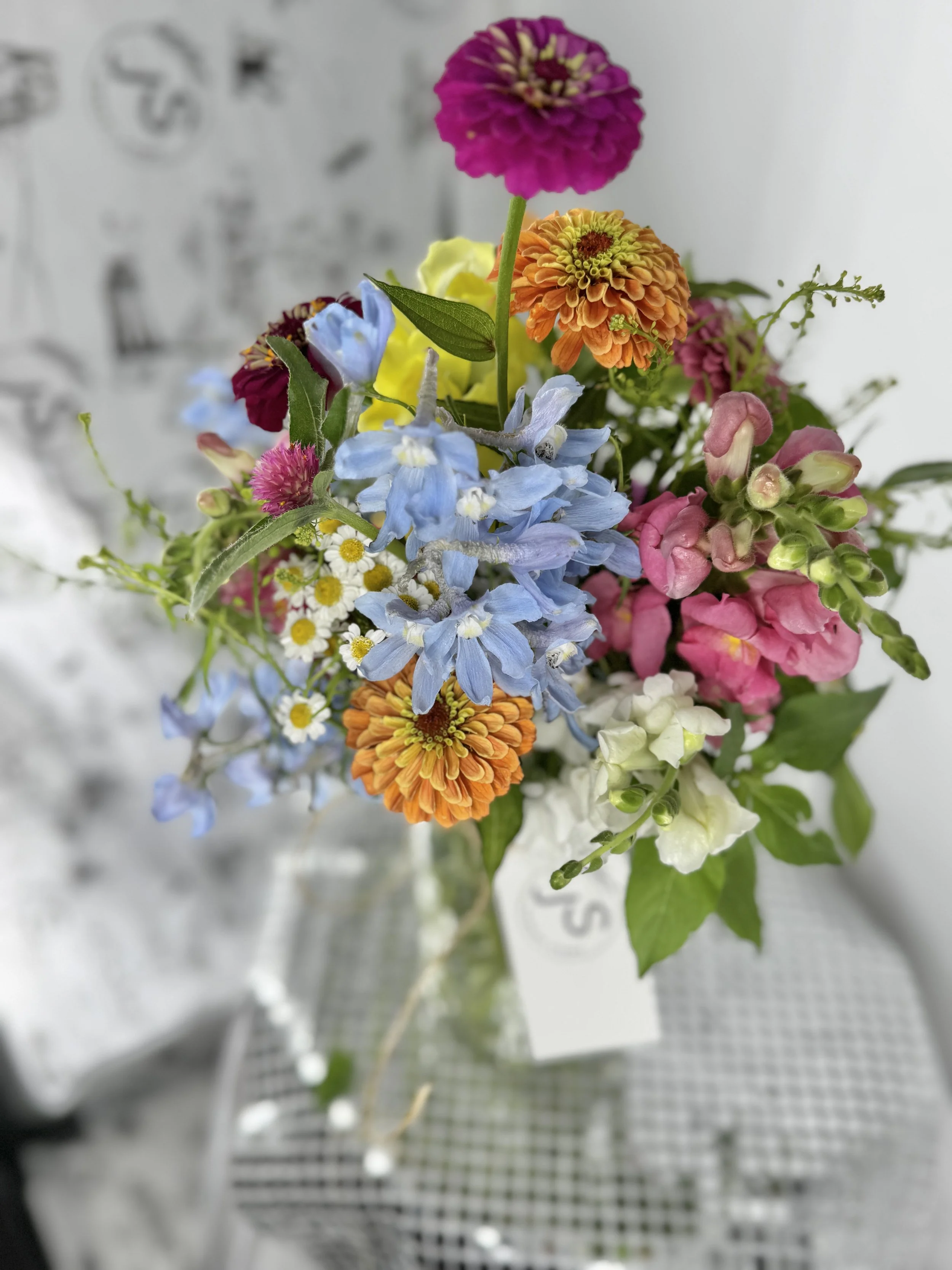 Colorful mixed flower bouquet in a glass vase on a table.