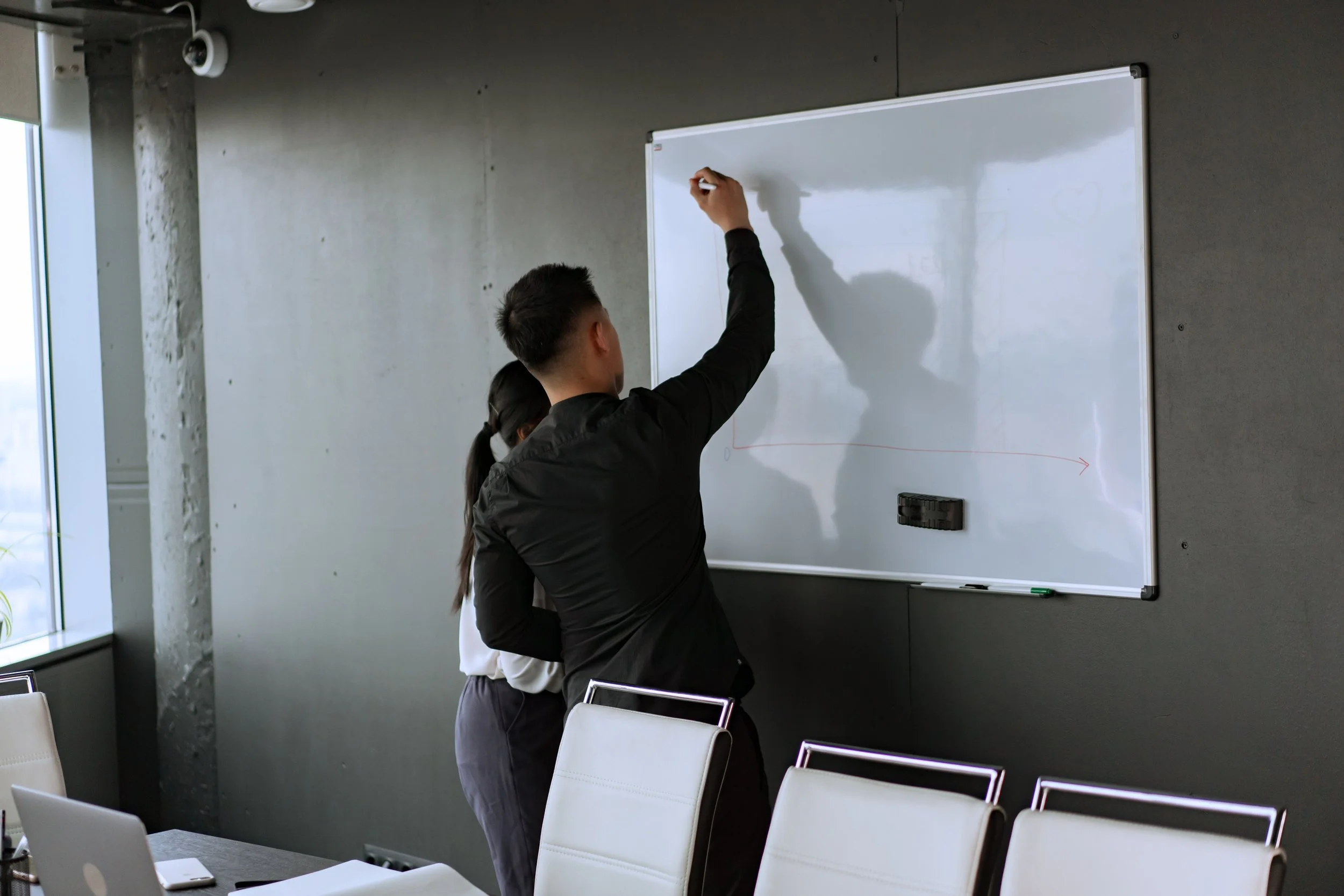 Two people at a whiteboard.