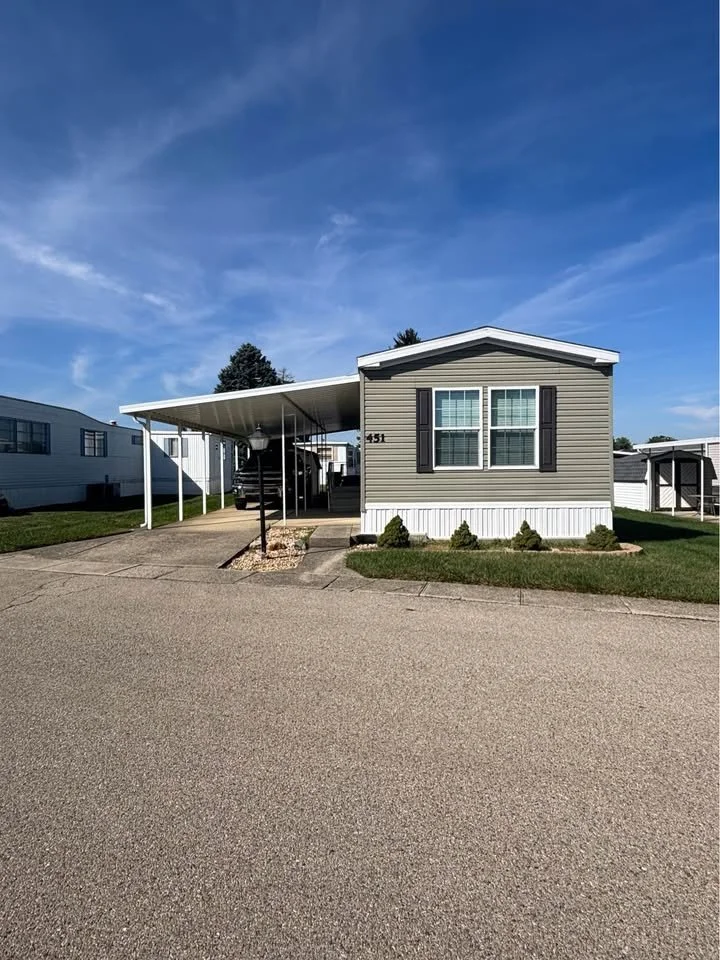 Manufactured home with covered carport at Red Oak mobile home park a 55 and over community