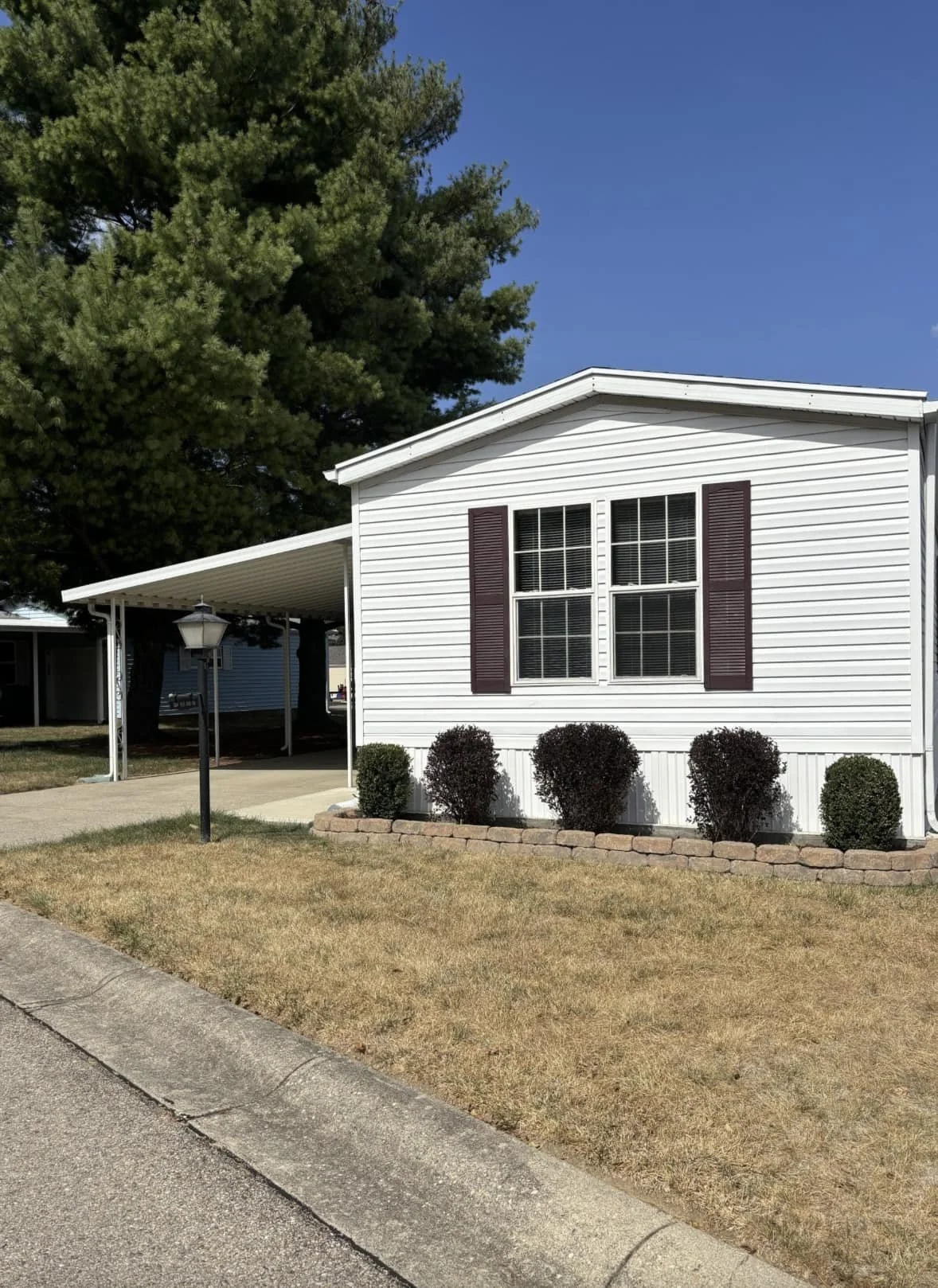 Manufactured home with carport at Red Oak Mobile Home Park