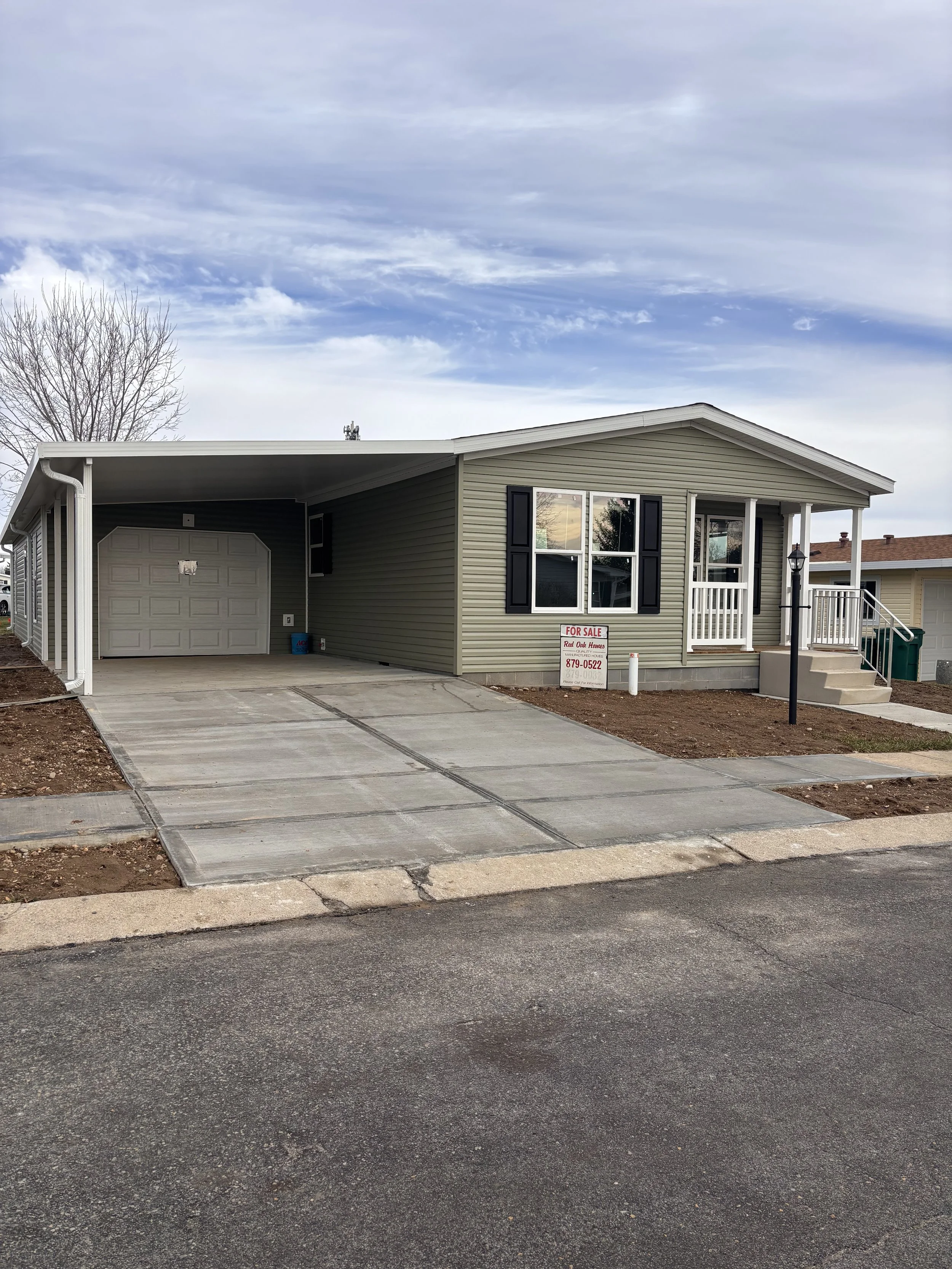 Manufactured home for sale at South Point Village, with a garage and awning in Fairborn, Ohio