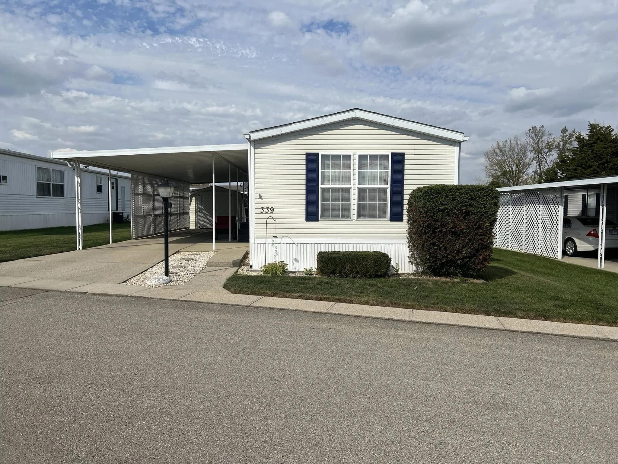 White manufactured home with carport at Red Oak Mobile Home Park