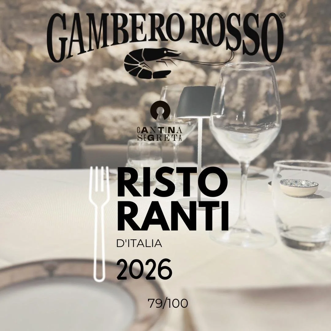 Menu del ristorante Ristotranti d'Italia 2026, con il logo Gambero Rosso, una forchetta, bicchieri e un piattino, con sfondo di un muro di pietra.