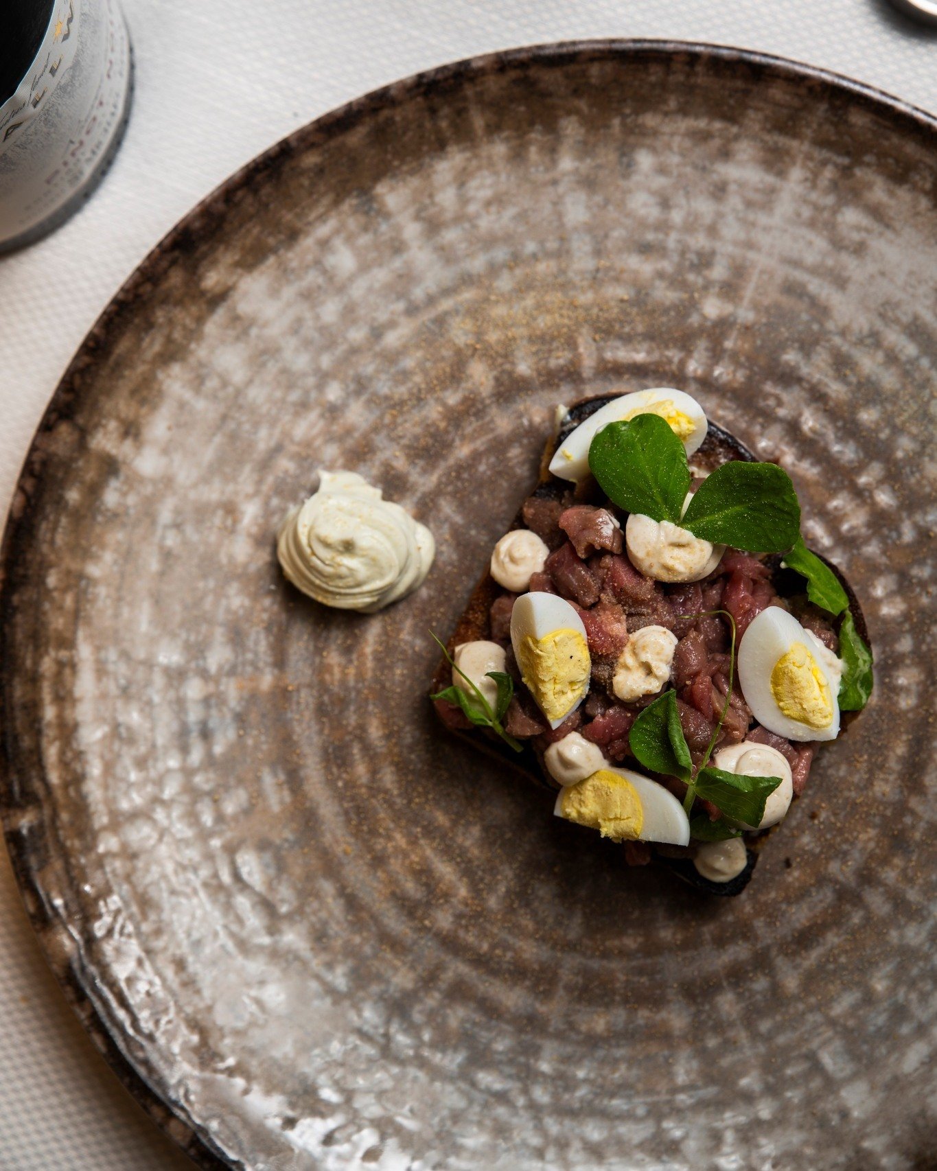 "𝐂𝐚𝐫𝐧 𝐜𝐫𝐮̀𝐚."

Carne cruda battuta al coltello di bufalo campano, adagiata su un pan brioche all&rsquo;amaretto tostato. Accanto, formaggio blu di bufala, uovo di quaglia e tartufo fresco.

Un piatto che lavora su contrasti e profon