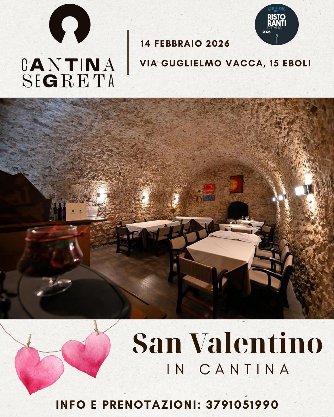 Interno di una cantina con pareti di pietra, tavoli apparecchiati con tovaglie bianche e sedie nere.