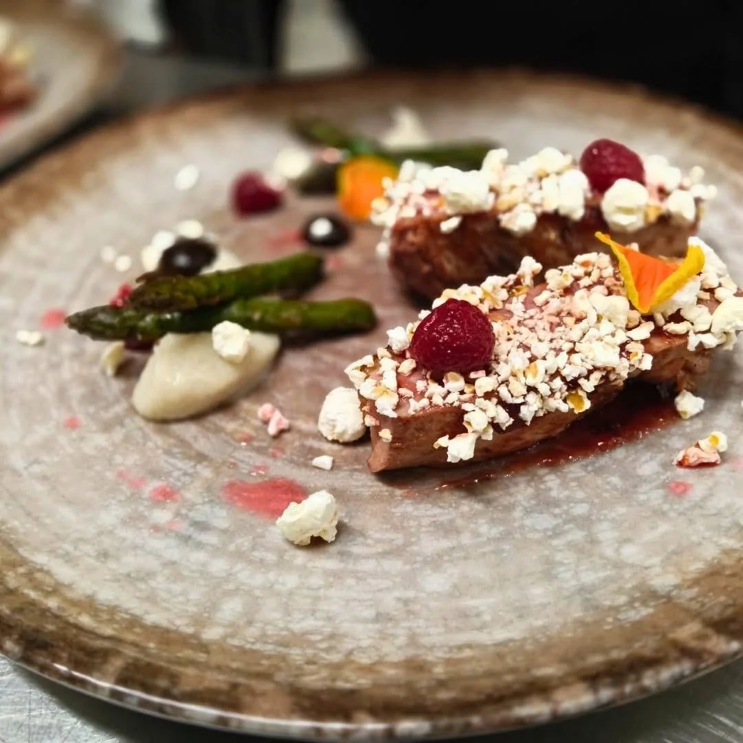 Piatto di carne con crosta di noci, servito con asparagi e salsa