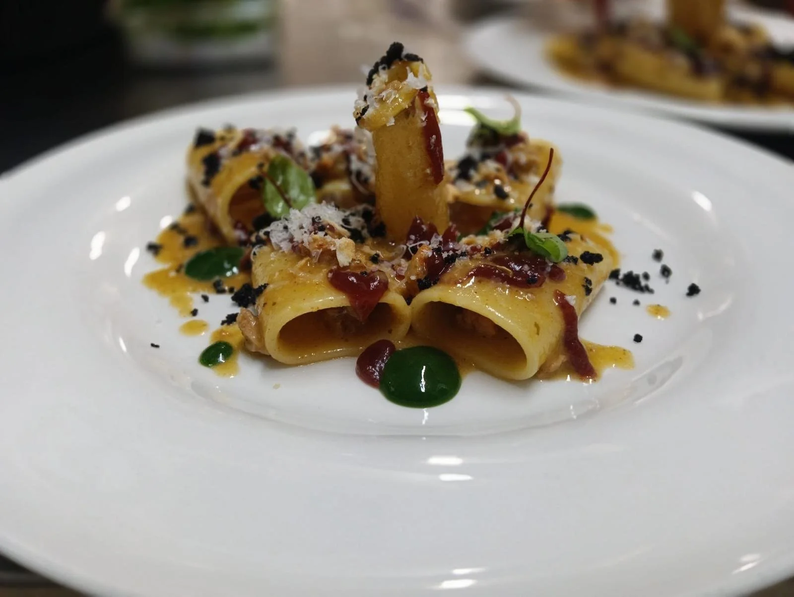 Pasta ripiena con salsa e decorazioni, guarnita con erbe fresche, in un piatto bianco