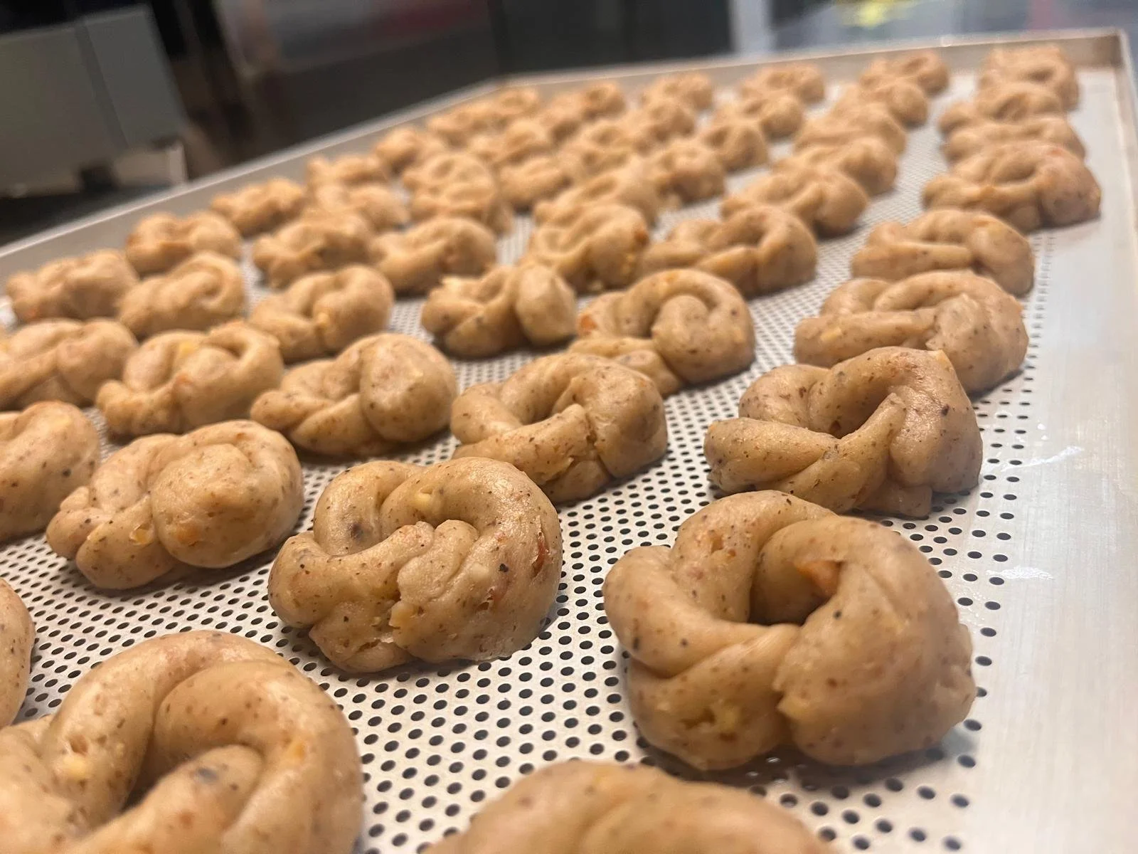 Ciambelle di pasta prima della cottura, disposte su una gratella.