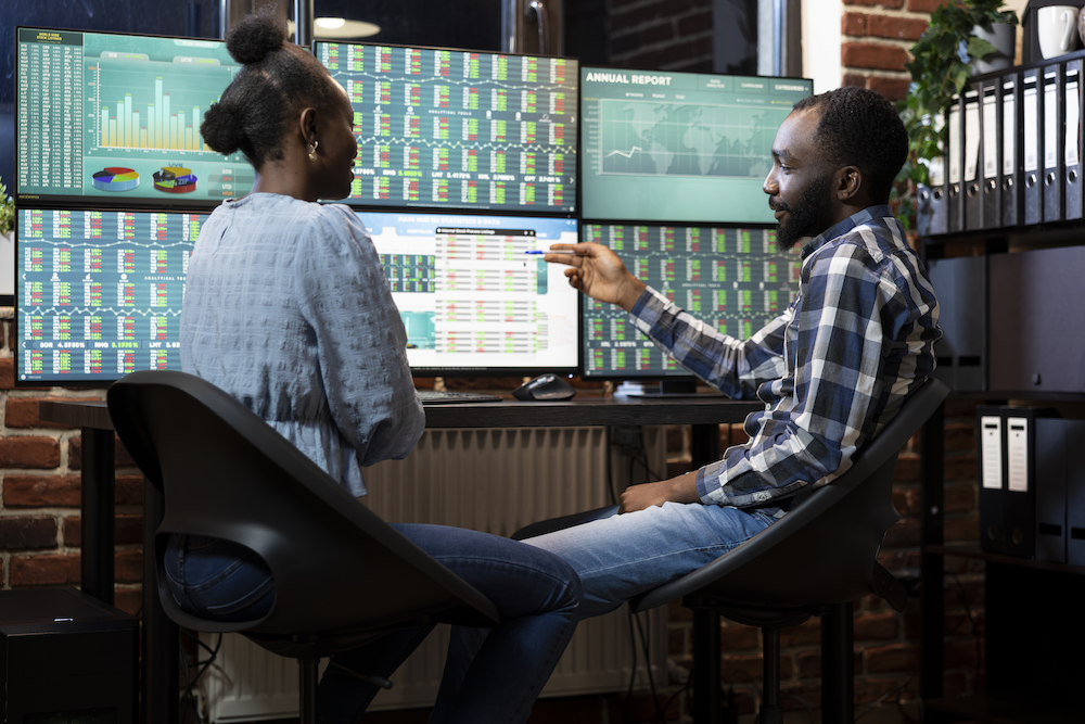 Two professionals reviewing data dashboards and analytics screens — AI-assisted workflow and process efficiency consulting by JT Donn, operations consultant based in Denver, CO