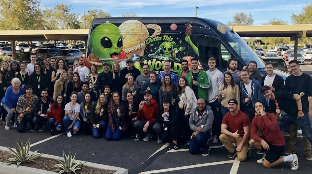 Large group of people gathered around Outta This World ice cream truck at corporate event in chesterfield  Missouri