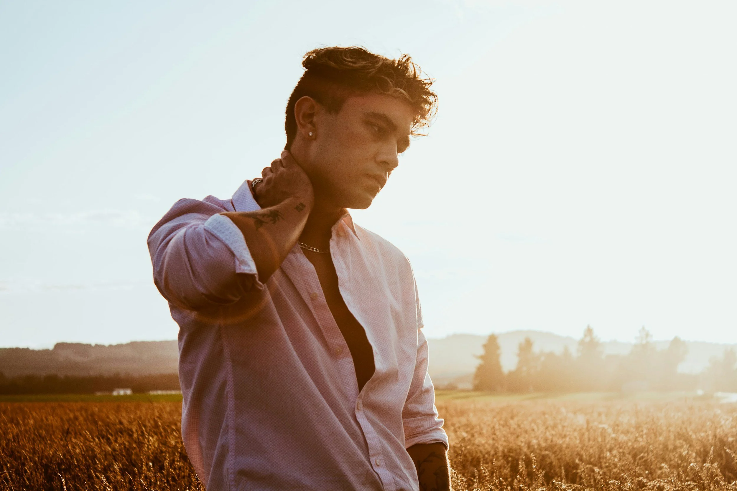 A person with physical tension standing outdoors, reflecting on the effects of trauma on the nervous system and the healing process of trauma recovery.