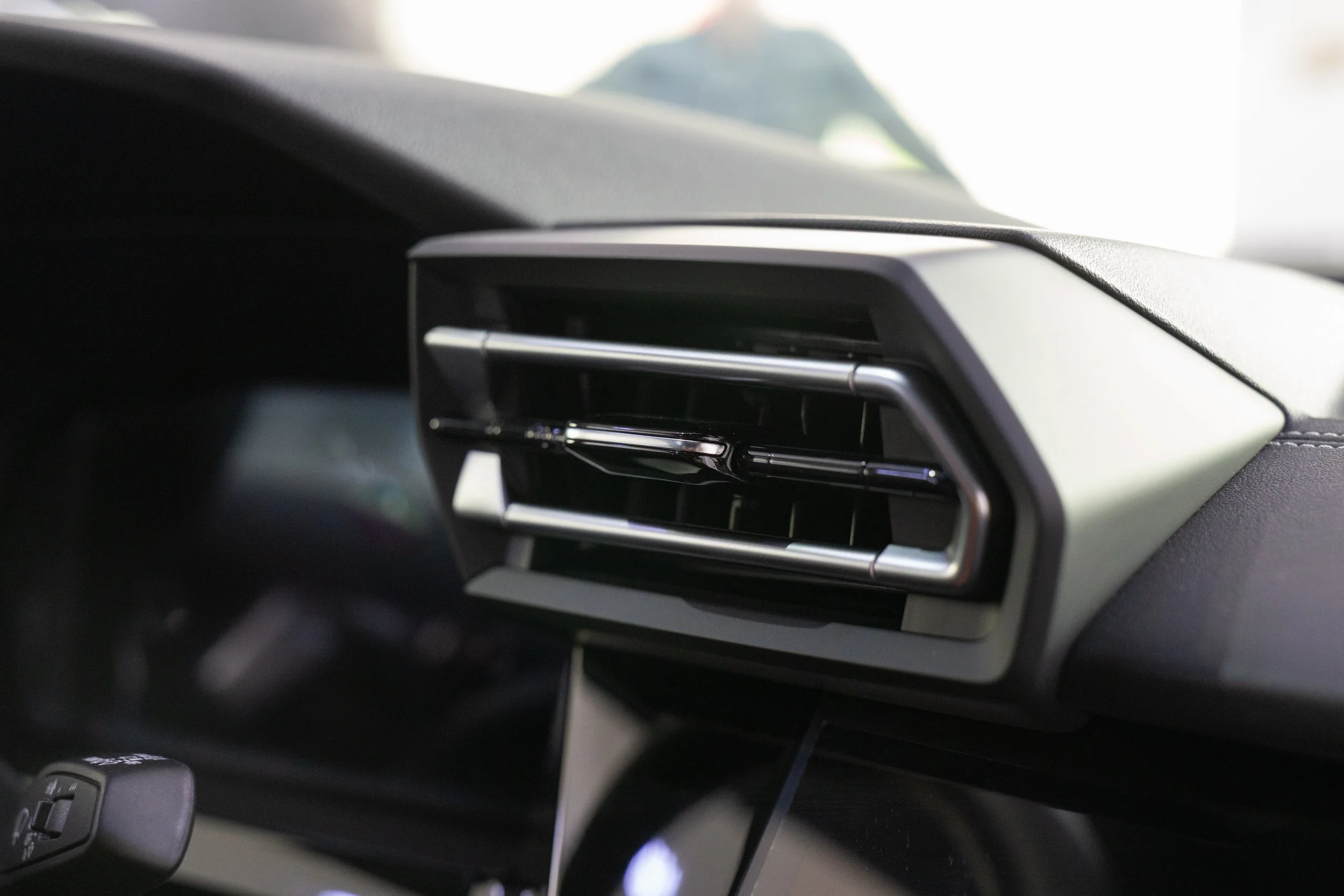 Close-up of a car's interior dashboard vent with a metallic finish.