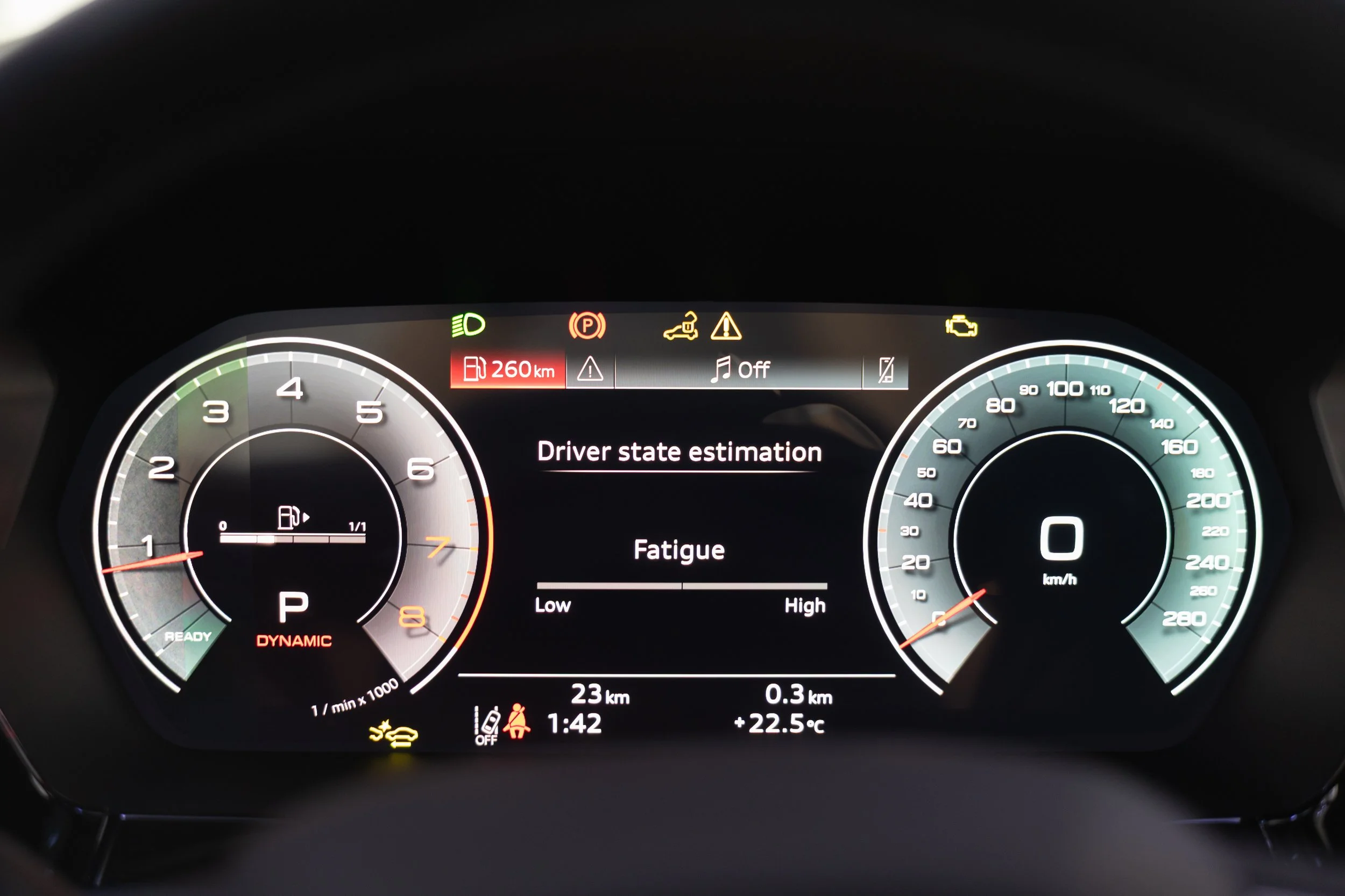 Car dashboard showing fuel range of 260 km, warning lights, driver state estimation of fatigue, and digital speedometer at 0 km/h.