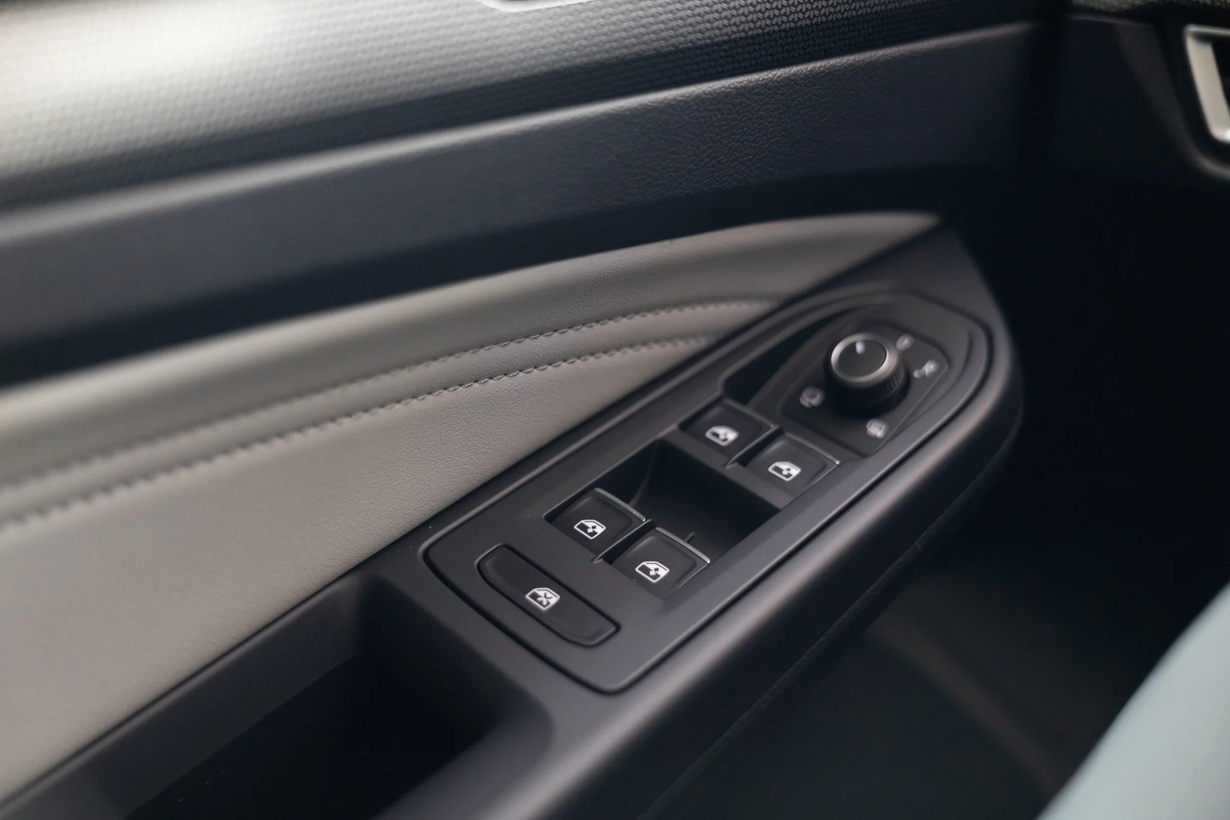 Close-up of a car door panel with power window controls.