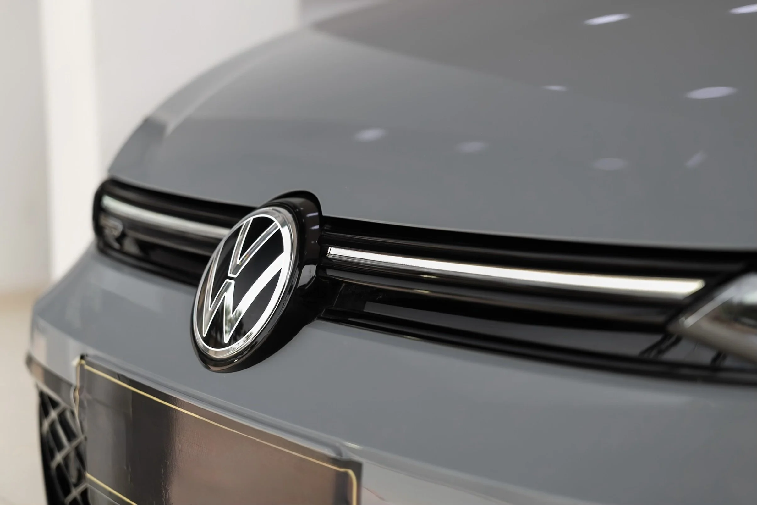 Close-up of a Volkswagen car front, showcasing the VW emblem on the grille.