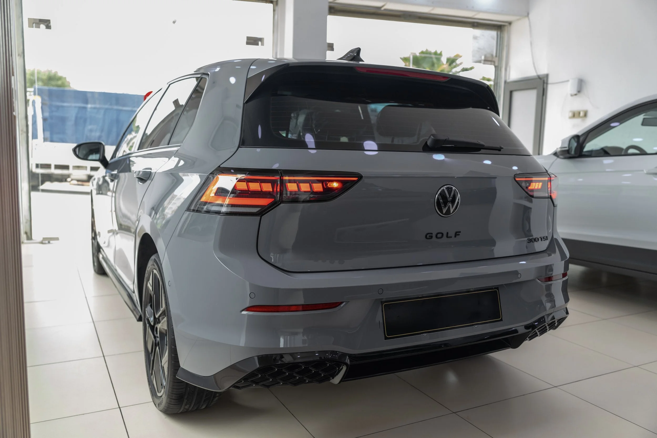 A silver Volkswagen Golf parked inside a car dealership showroom.