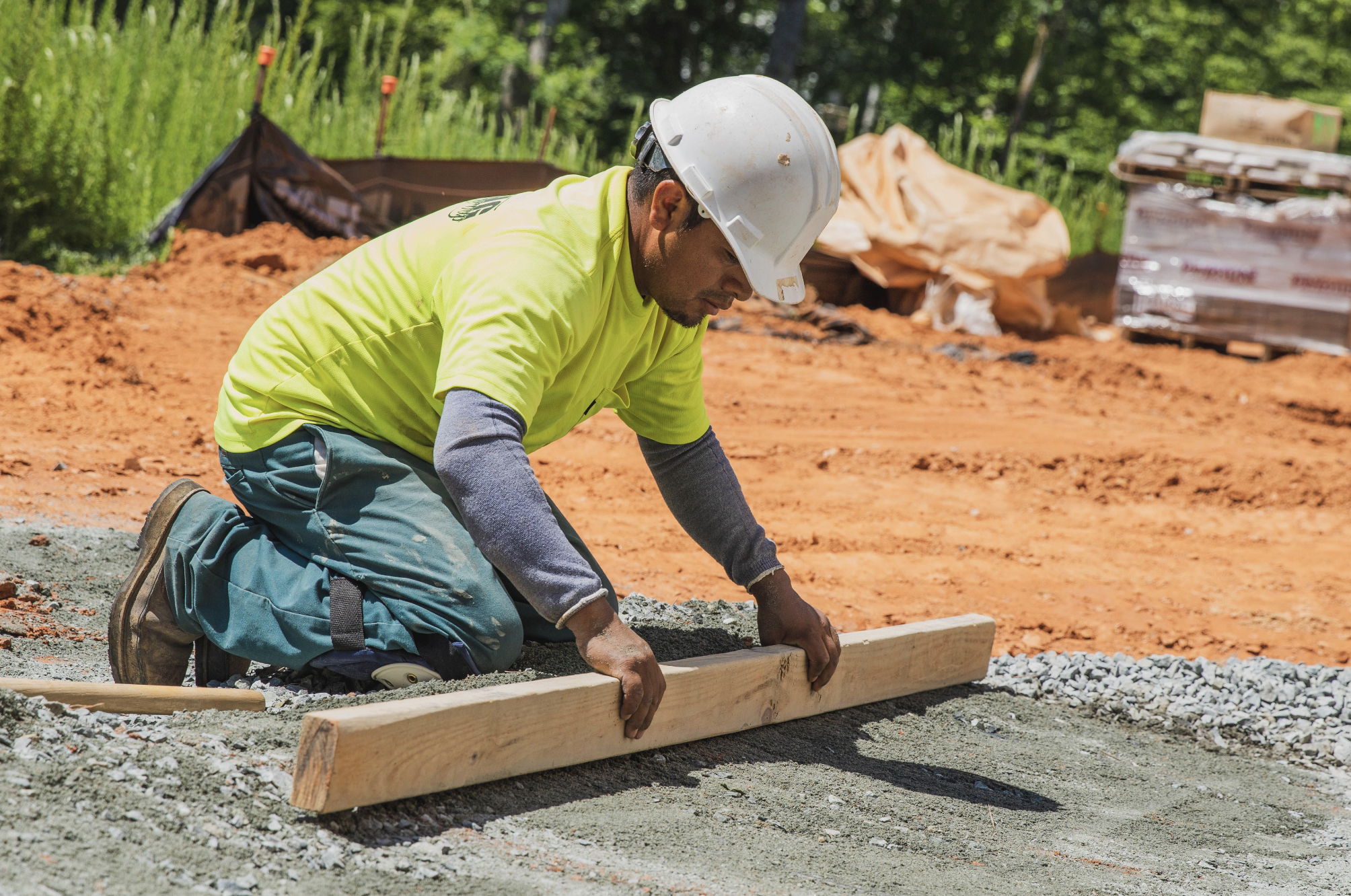 LOVING TEAM member in Charlotte leveling gravel for an outdoor living installation project.