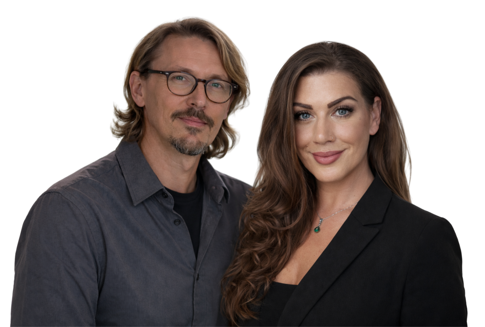 A man with glasses and long, wavy hair standing next to a woman with long, wavy brown hair and blue eyes, both smiling and dressed in dark clothing.
