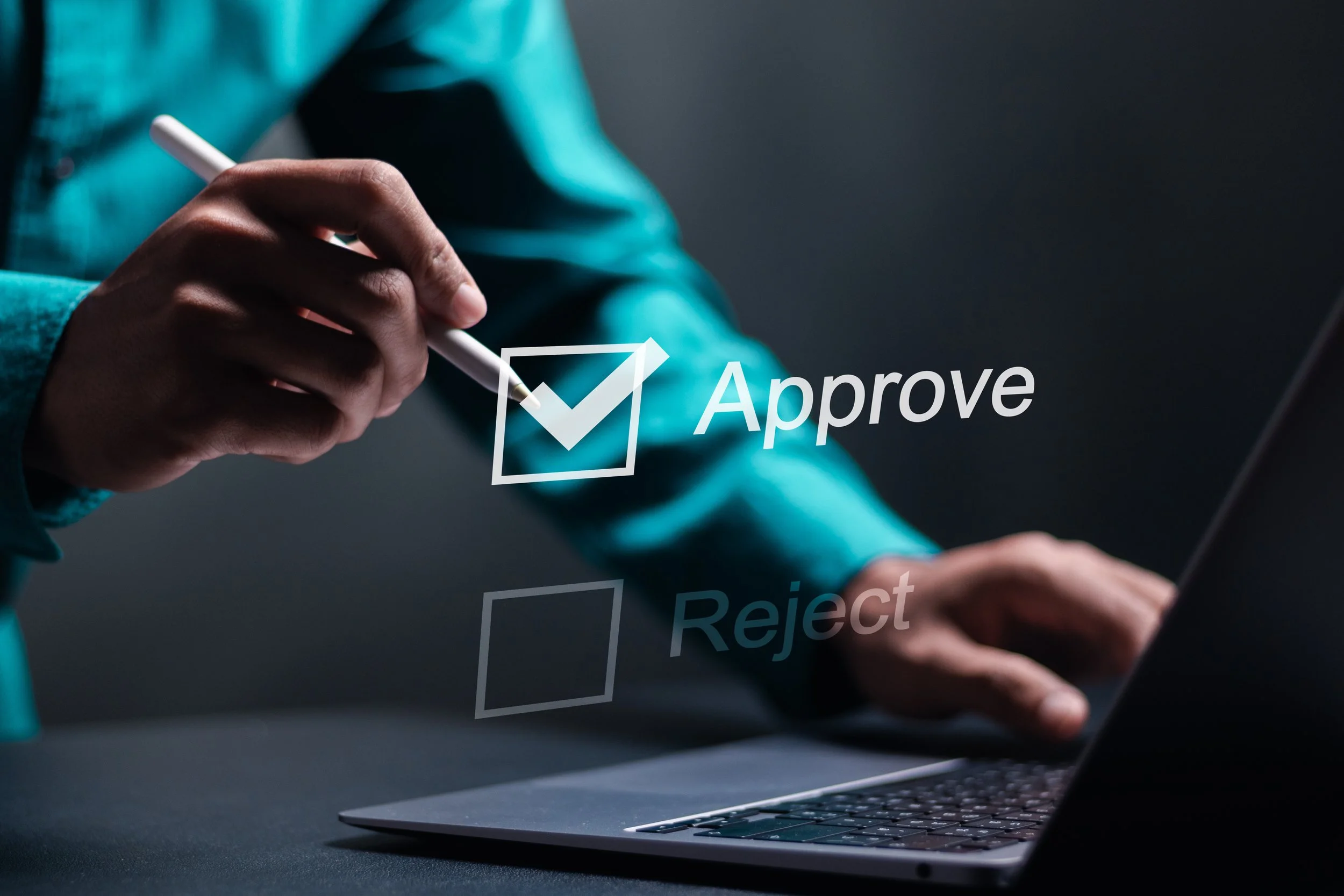 Person using a stylus to select the 'Approve' option on a computer screen with checkboxes for approve and reject.