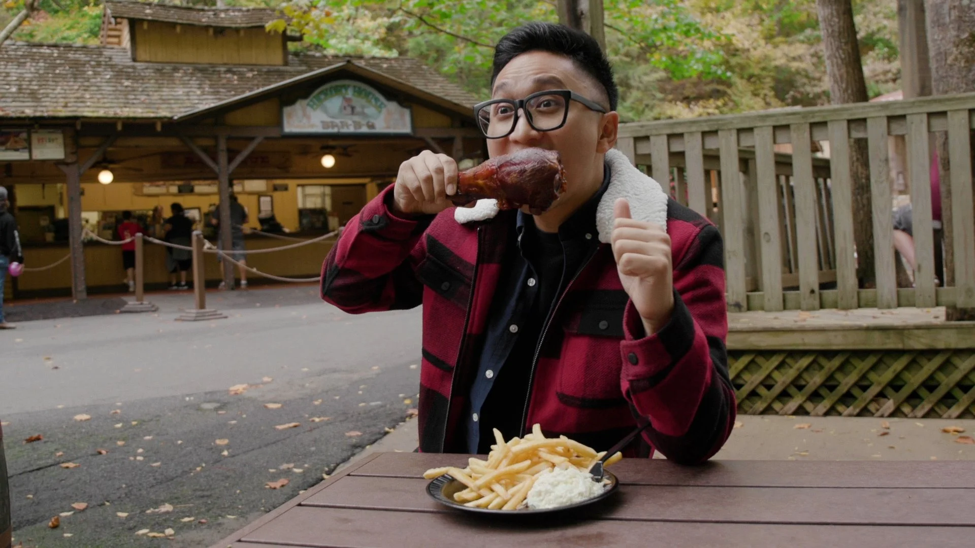 Gunnarolla takes a bite of a pork leg at a theme park in the series Nom Voyage