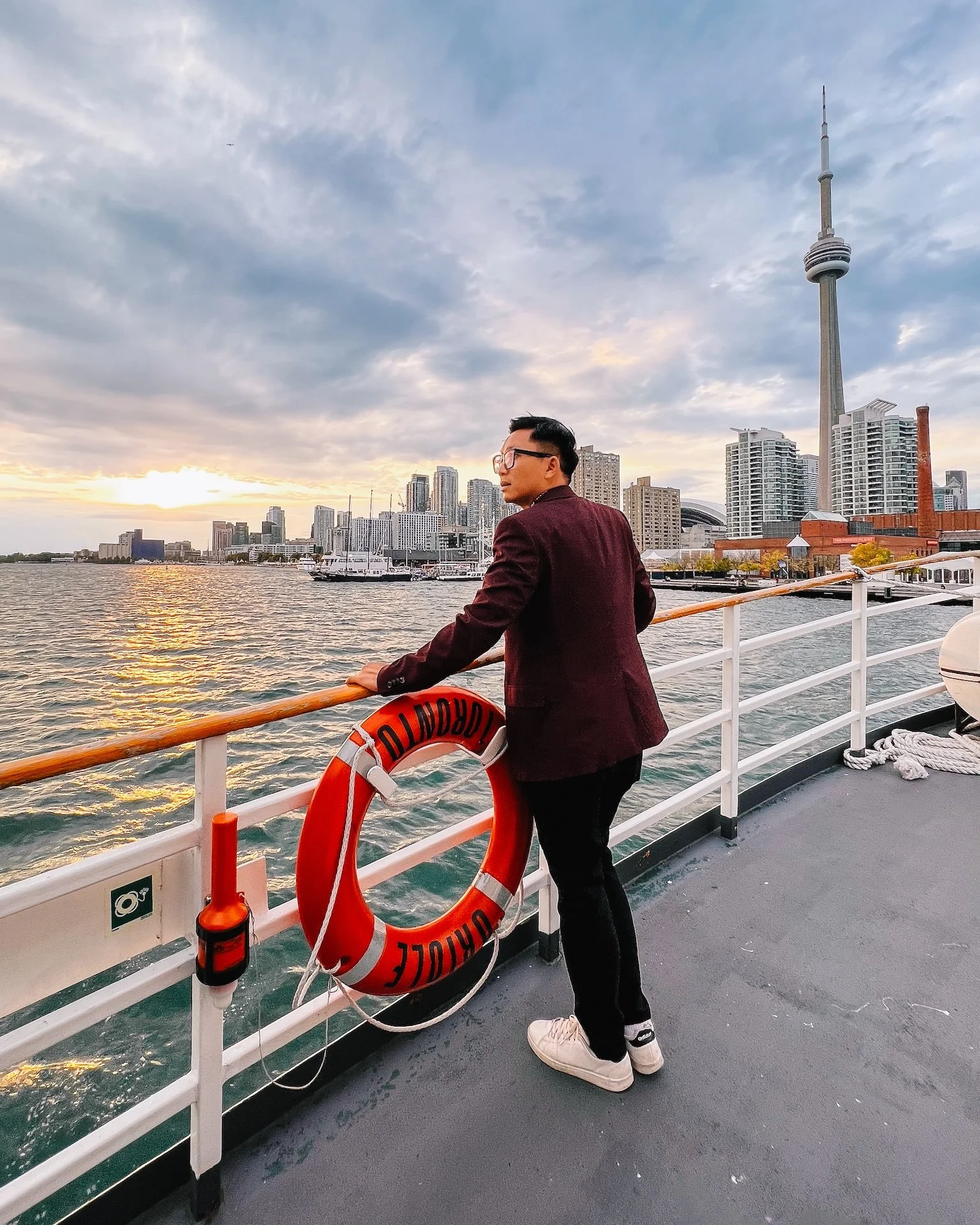 Gunnarolla looks toward the city skyline, including the CN Tower, during sunset with clouds in the sky.