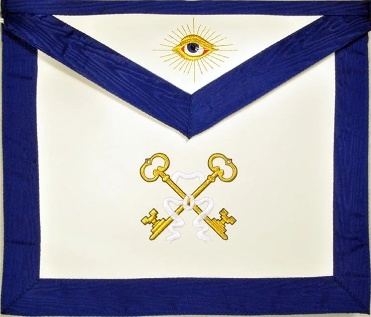 A large white cloth with a blue border, featuring an eye with rays above and two crossed gold keys, representing the Lodge Treasurer below.