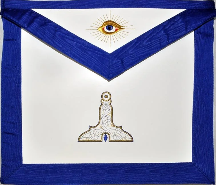 A white masonic apron with a blue border featuring a gold and white all-seeing eye symbol with rays above. Below it is a white, gold, and blue level representing the Senior Warden.
