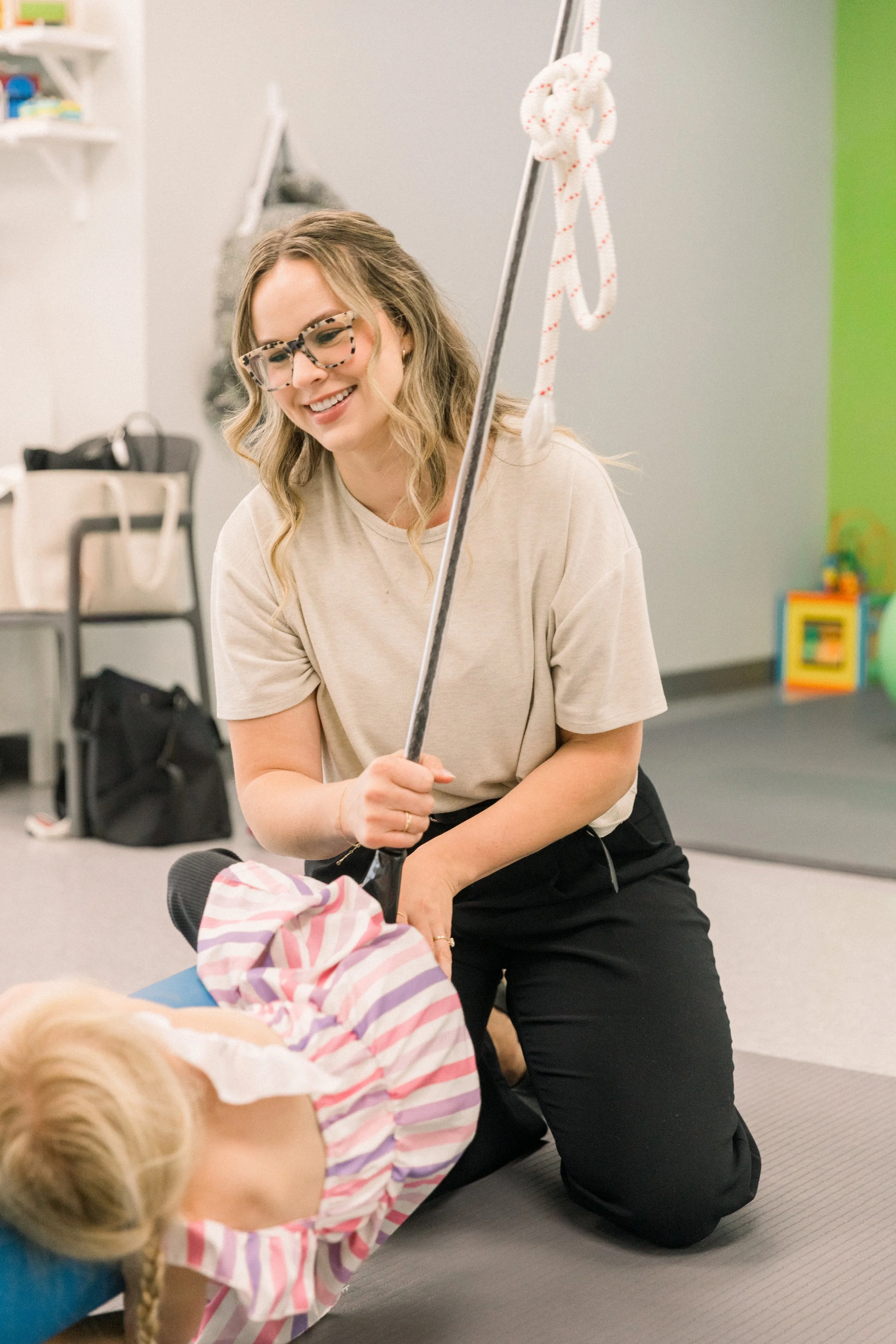 Speech therapist using a sensory swing during a private speech-language therapy session.