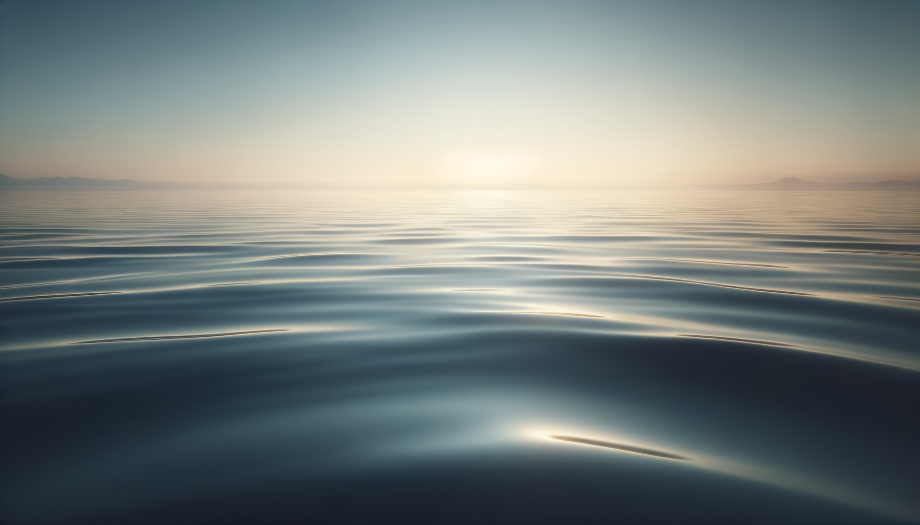Calm ocean water with gentle ripples and distant mountains on the horizon during sunrise or sunset.