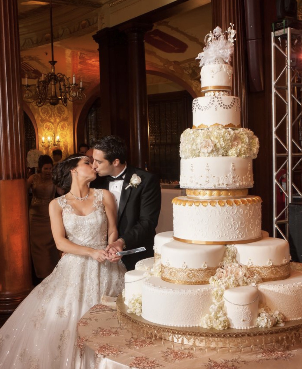 multi-tier gold and white wedding cake with floral spacer tier at Flagler College Ponce de Leon Ballroom by Sweet Weddings Cakes