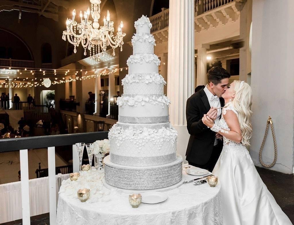 7-tier silver and white grand-scale wedding cake overlooking the historic ballroom at the Lightner Museum by Sweet Weddings Cakes