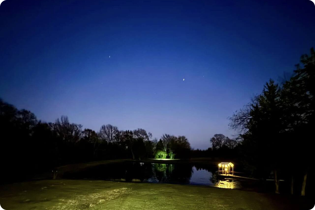 Clear starry night sky reflecting over a calm private pond at Pinoy Ranch in the countryside.