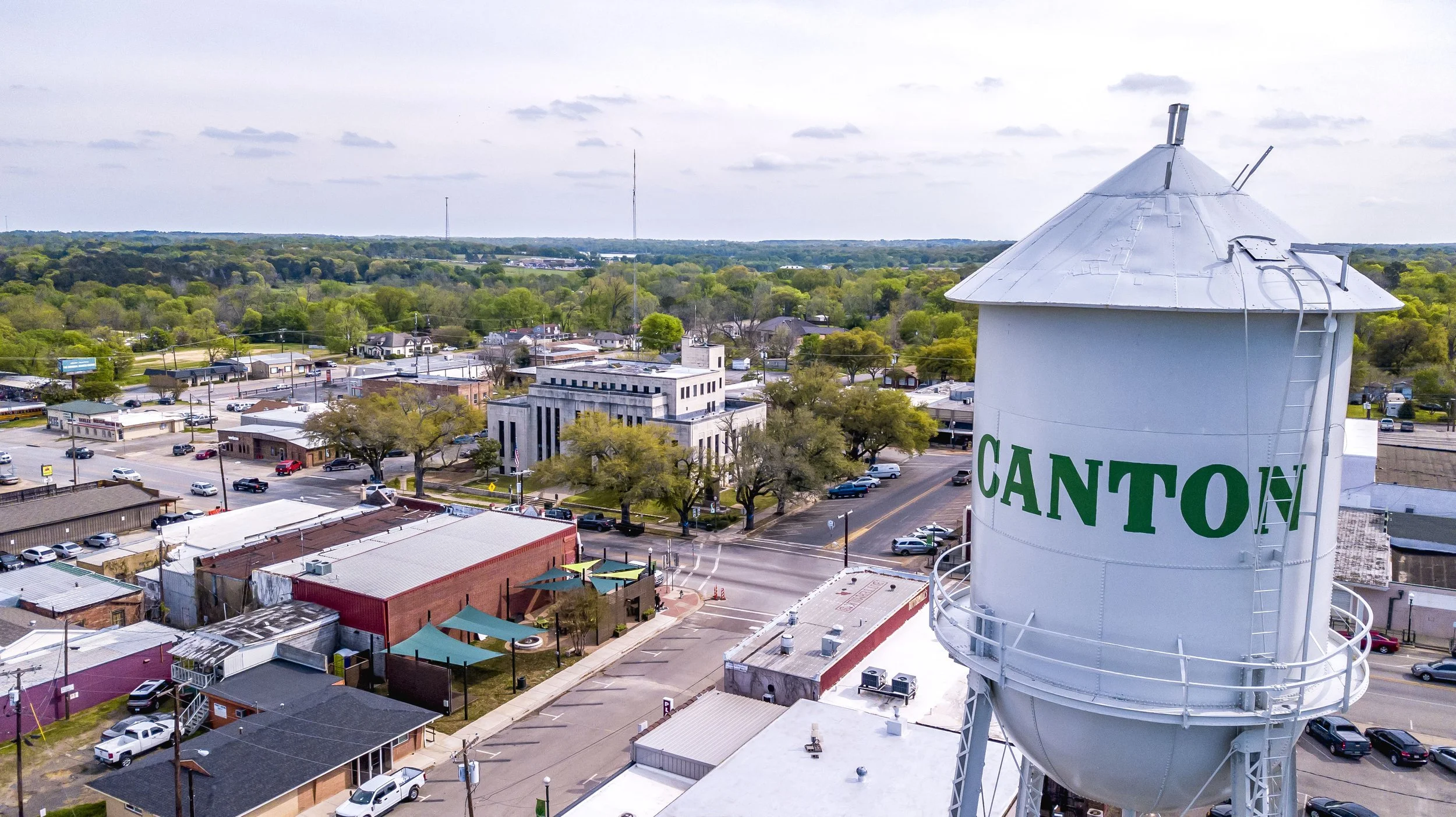 Aerial view of downtown Canton, TX featuring the iconic white water tower, historic buildings, and local streets near Pinoy Ranch.