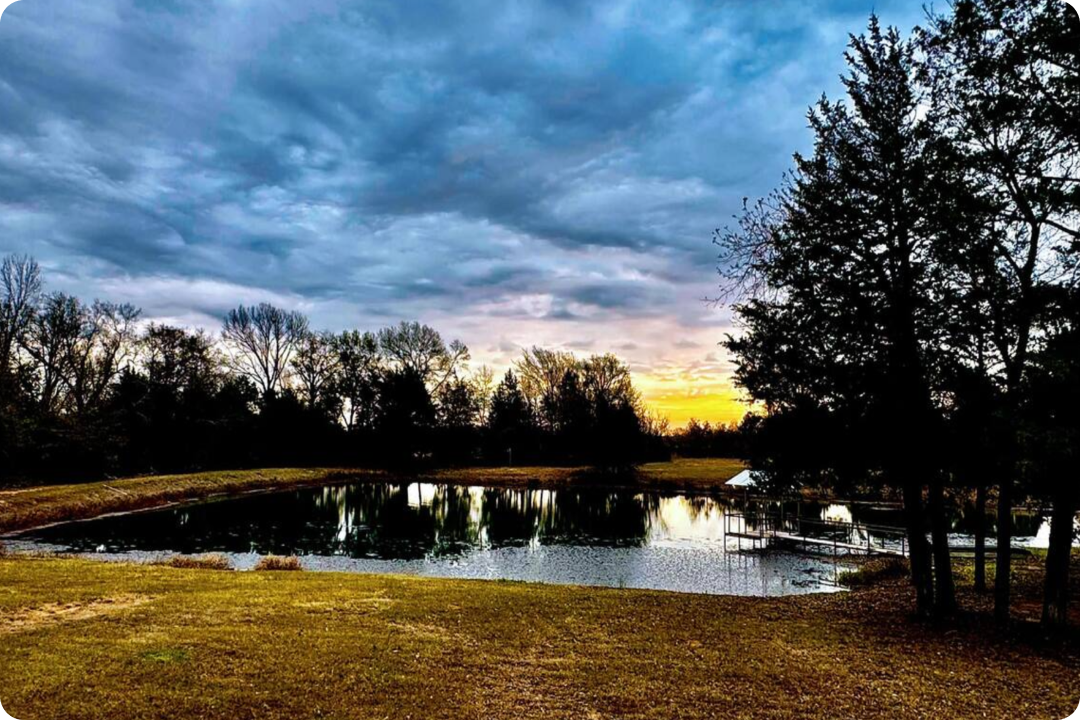 Scenic private fishing lake at sunset stocked with bass and catfish on an East Texas ranch.
