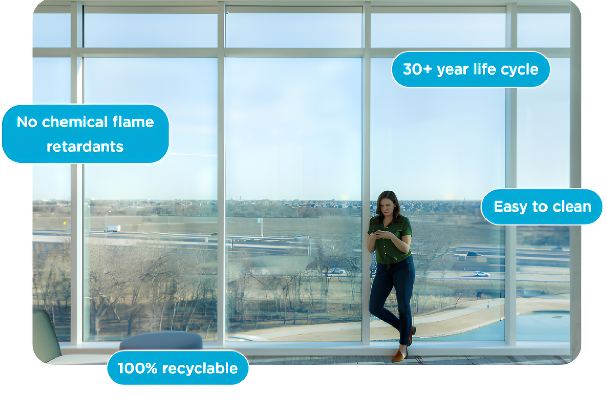 Interior of a building with large windows and a woman standing inside, showing features of eco-friendly, recyclable glass with a 30+ year life cycle, no chemical flame retardants, easy to clean, and 100% recyclable.