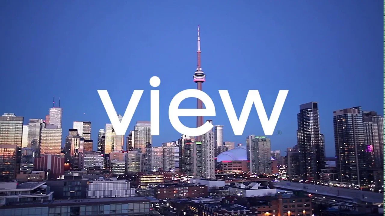 Downtown Toronto skyline at dusk with CN Tower in center, city lights on