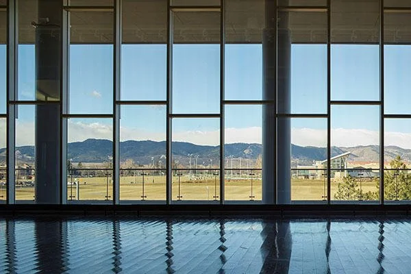 A large window with multiple panes showing a mountain landscape and blue sky.